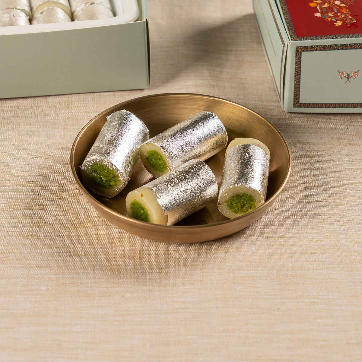 Dadu's Badam Pista Roll pieces with silver varq on serving plate